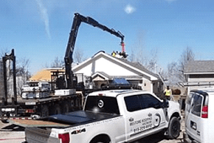 A white truck with a crane on top of it.